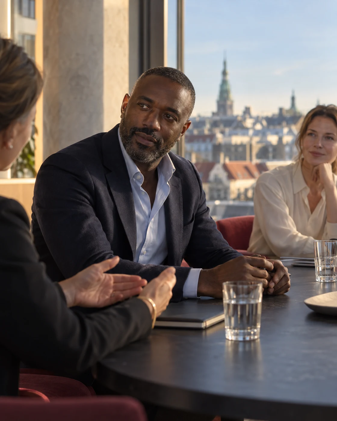 Illustrative business leader listening to colleagues in a city office